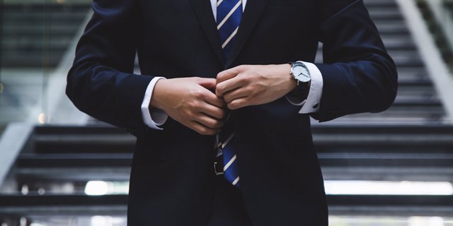 Photo of a businessman adjusting a tie